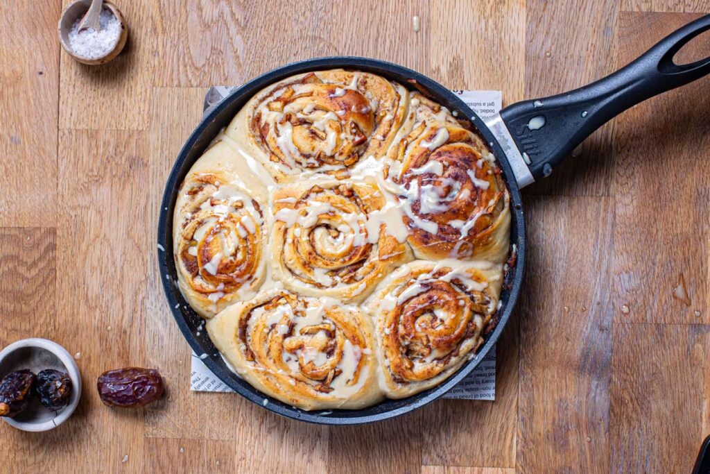 vegane apfel zimt schnecken gebacken in pfanne von oben auf holztisch mit deko