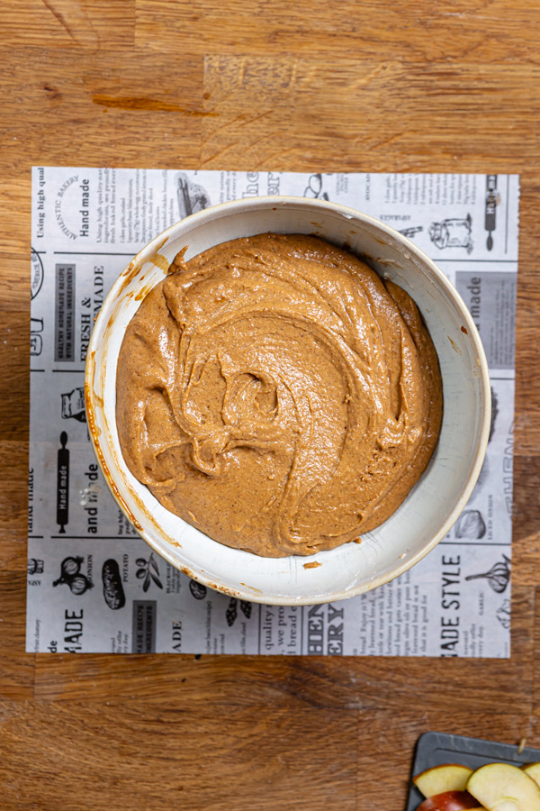 fertiger teig fuer gesunder apfelkuchen in einer schuessel von oben fotografiert auf einem holztisch