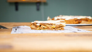 frontal aufnahme von einem stueck glutenfreier apfelkuchen auf einem holztisch