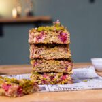gestapelte baked oats stuecke von vorne auf einem holztisch mit dekoration