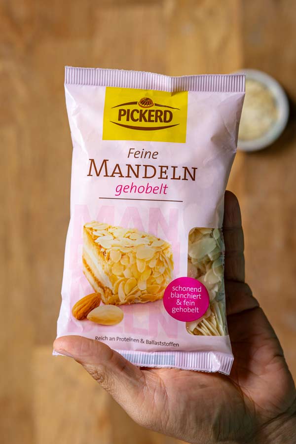 eine packung gehobelte mandeln von pickerd von oben ueber holztisch