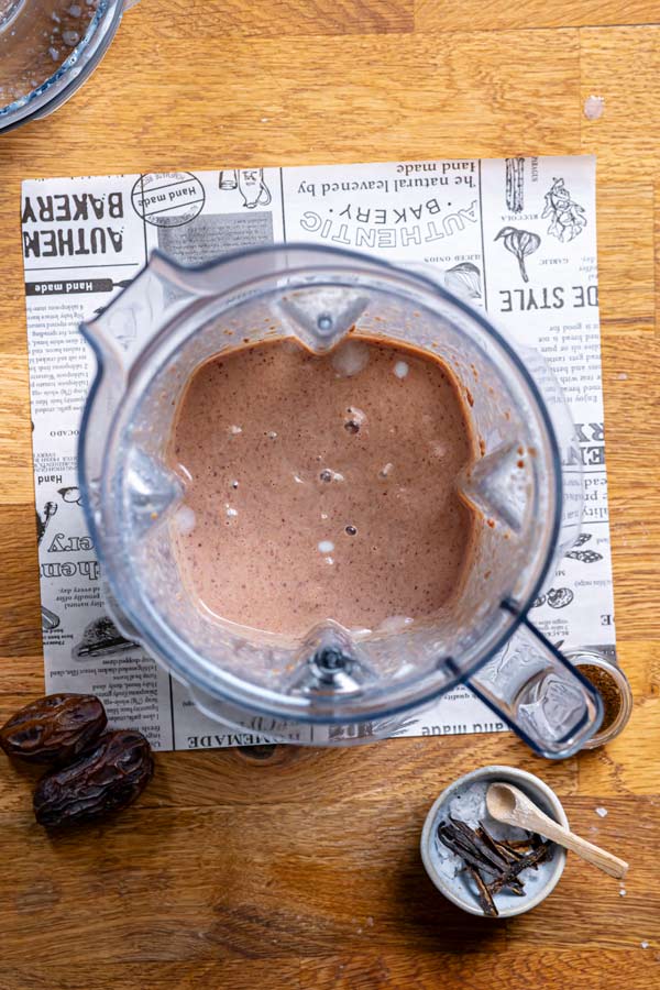 pürierte bohnen creme in eine mixbehaelter von oben auf weissem backpapier