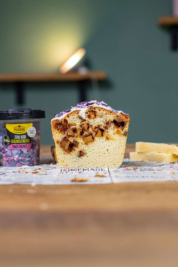 ruehrkuchen mit apfel von vorne angeschnitten auf einem tisch