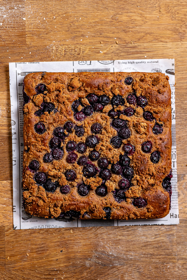 fertig gebackener viereckiger blaubeer streusel kuchen von oben auf einem holztisch