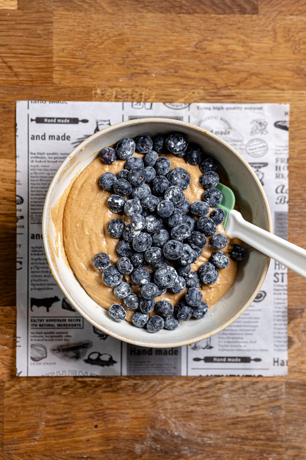 teig und blaubeeren in einer schuessel von oben aufgenommen auf einem holztisch