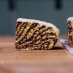 ein stueck kuerbis marmorkuchen von der seite frontal aufgenommen auf einem holztisch