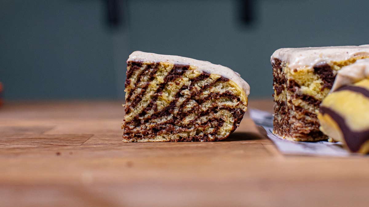ein stueck kuerbis marmorkuchen von der seite frontal aufgenommen auf einem holztisch