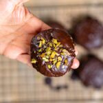 ein elisenlebkuchen in hand von oben nahaufnahme mit weiteren lebkuchen im hintergrund