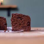 ein stueck brownie fuer gesundes schnelles fruehstueck von vorne auf einem holztisch