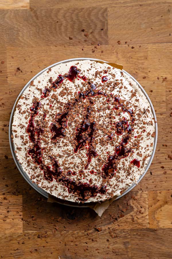 fertig zusammengesetzte und garnierte gesunde schwarzwaeldertorte von oben auf einem holztisch
