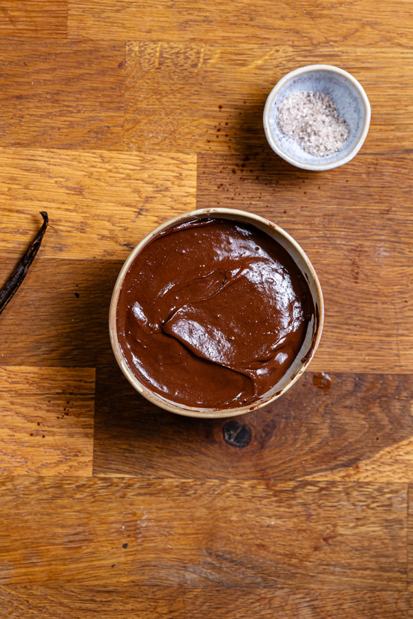 fertige dattel haselnuss creme in einer kleinen schuessel von oben auf holztisch mit deko