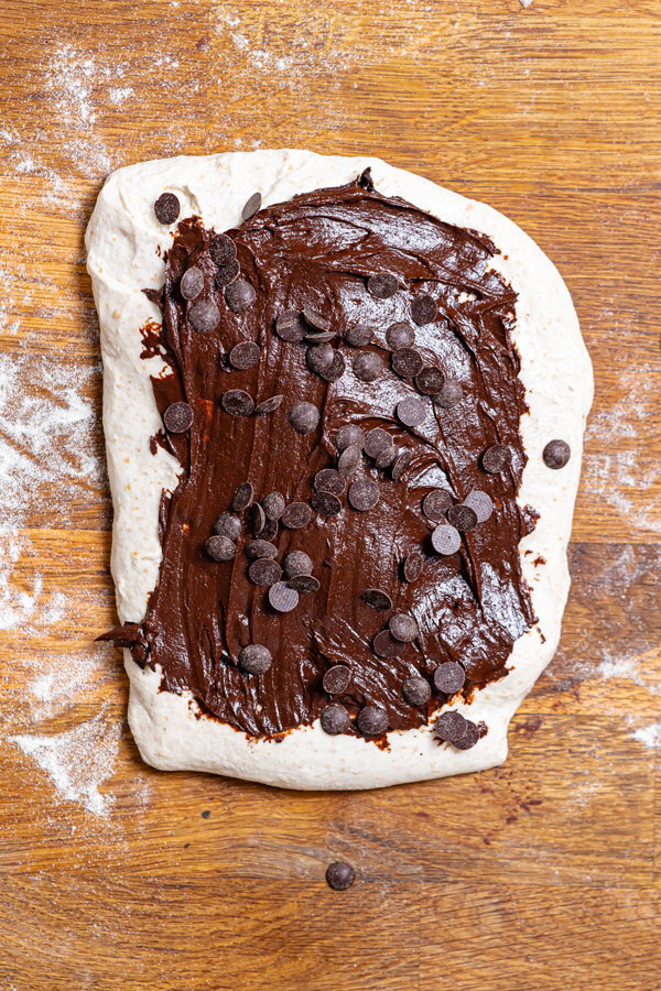 dattel haselnuss creme auf einem ausgerollten sauerteigboden von oben auf einem holztsich