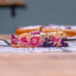 ein stueck gesunder obstkuchen auf kuchenschaufel von der seite auf einem holztisch