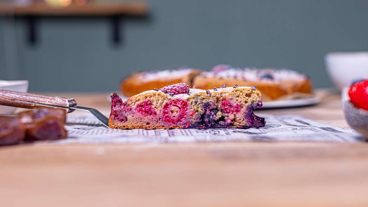 ein stueck gesunder obstkuchen auf kuchenschaufel von der seite auf einem holztisch