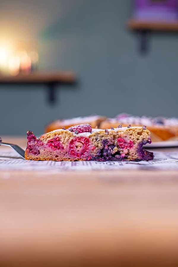 stueck gesunder obstkuchen mit sichtbaren beeren von der seite auf einer kuchenschaufel