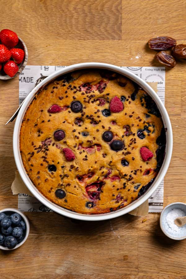 gebackener obstkuchen in springform von oben auf einem holztisch mit dekoration