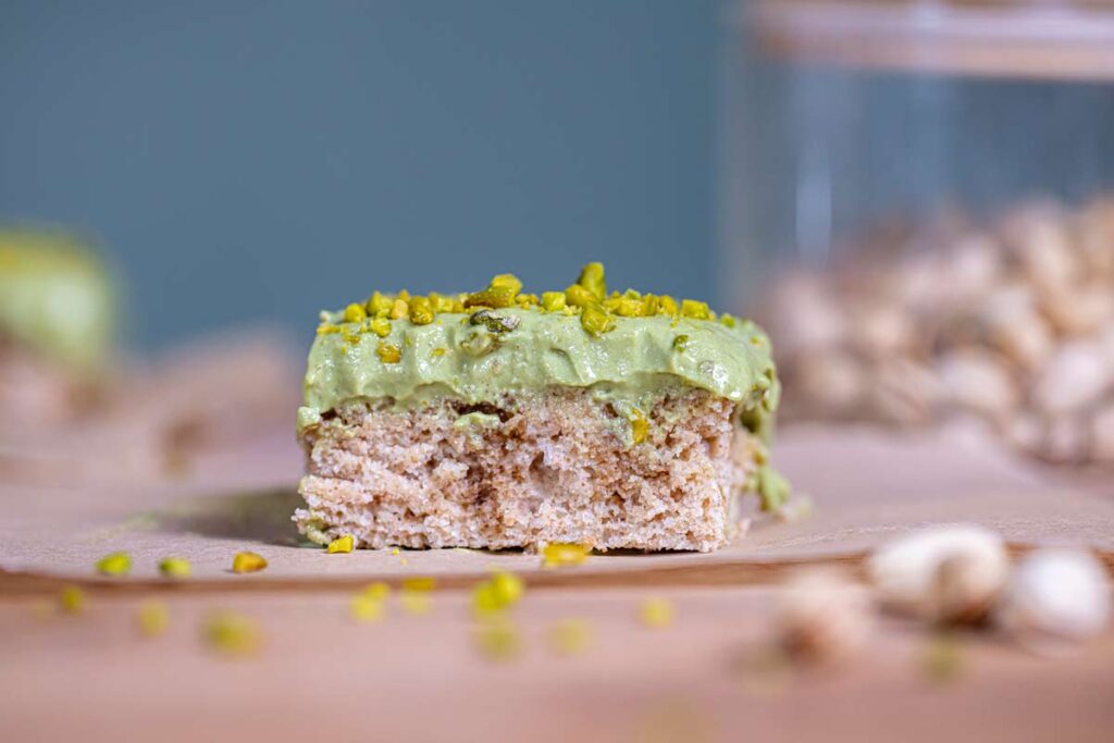 ein stueck tiramisu mit pistaziencreme von vorne mit pistazien stücken garniert