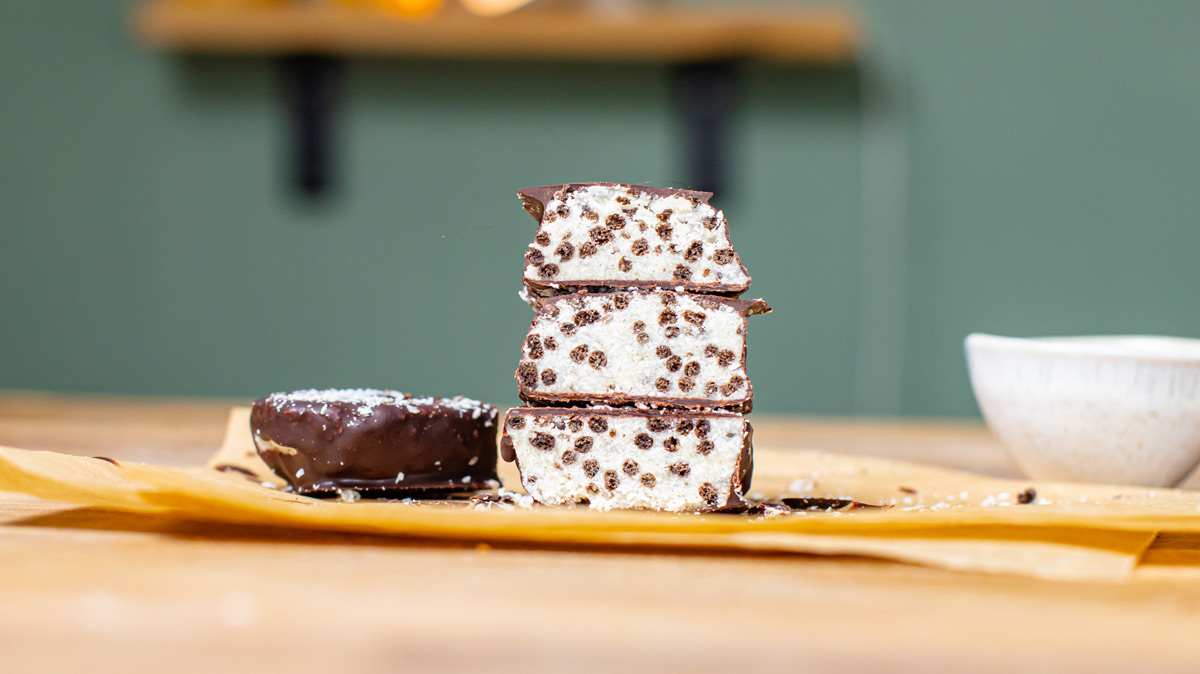 gesunde proteinriegel aufgeschnitten und gestapelt frontal auf einem holztisch mit deko