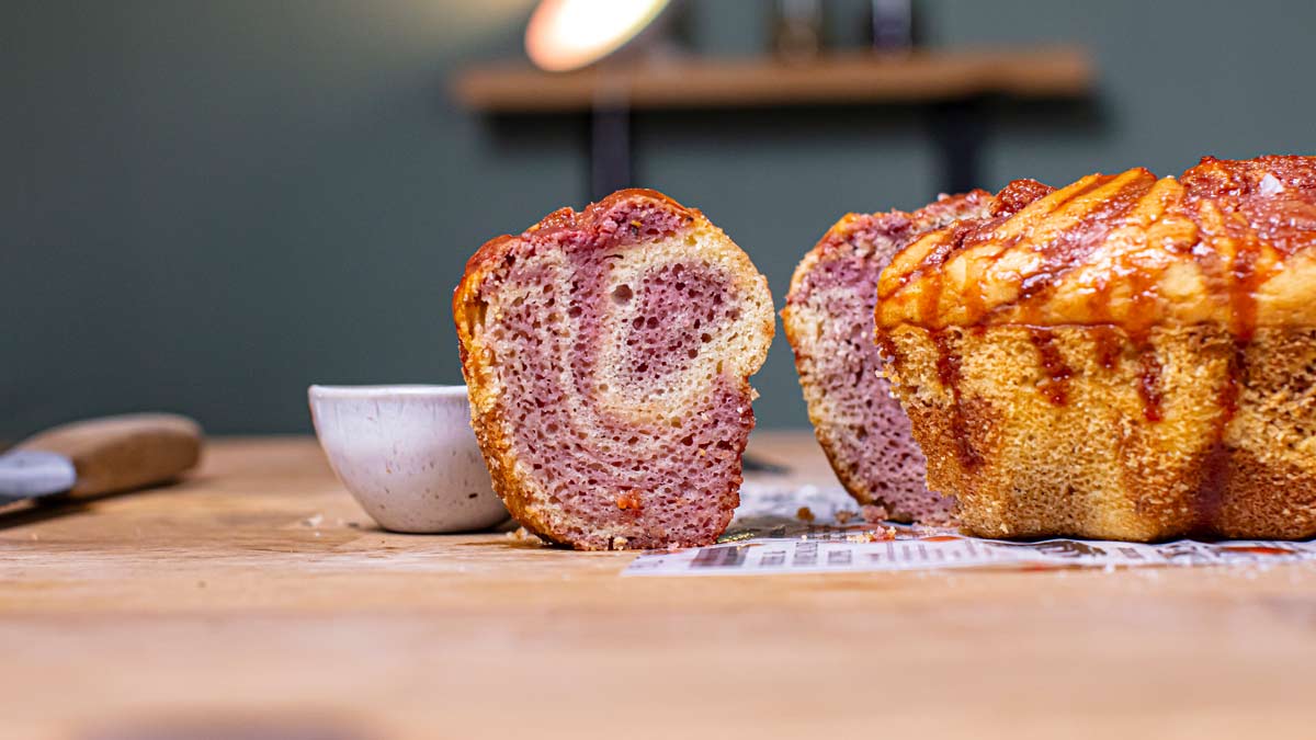 ein stueck saftiger marmor kuchen herausgeschnitten mit sichtbaren rosa himbeer streifen