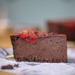 ein stueck schoko cheesecake mit beerenspiegel von seite