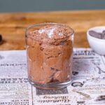 mousse au chocolat im glas auf backpapier mit dekoration