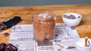 mousse au chocolat im glas auf backpapier mit dekoration