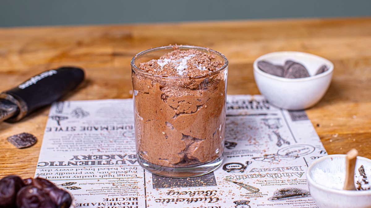 mousse au chocolat im glas auf backpapier mit dekoration