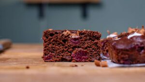 ein stueck schwarzwaelder kirsch kuchen von vorne auf einem holztisch