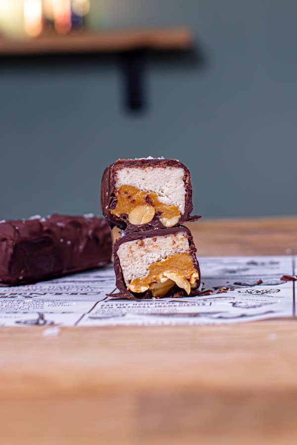 nahaufnahme snickers eis halbiert mit sichtbaren schichten von vorne auf holztisch