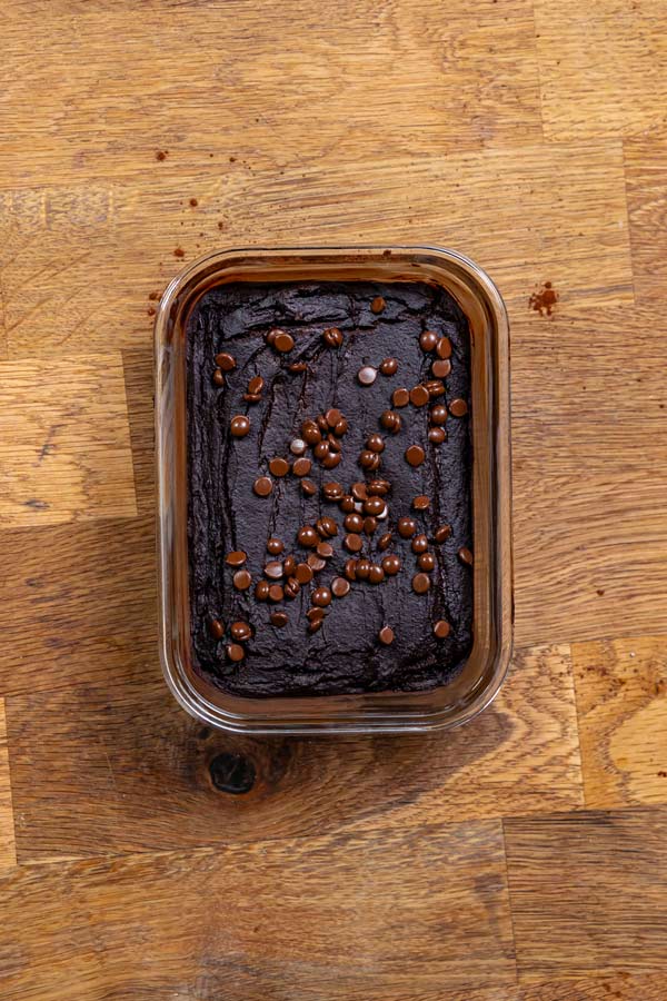 gebackener mit schokodrops garnierter weihnachts brownie von oben in glas behaelter auf holztisch
