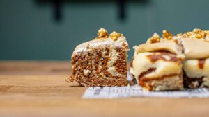 zimtschneckenkuchen von vorne mit einem herausgeschnittenen stück mit sichtbaren marmorierungen auf einem holztisch