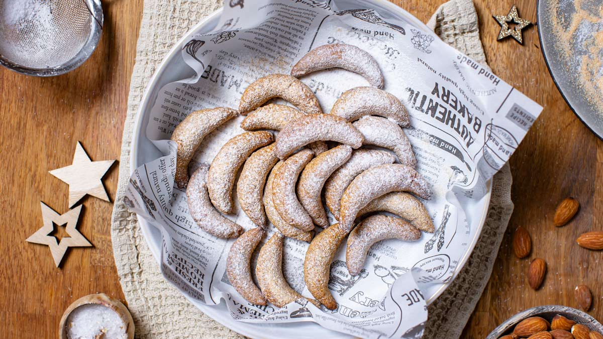 Vegane Vanillekipferl in einem Teller mit Puder Zucker